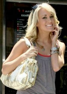 Carrie Underwood was spotted with a French designer Gerard Darel Redux Python bag in gold. Stunning even for shopping during the day! Other celebs that carry this bag are Angelina Jolie, Halle Berry and more.